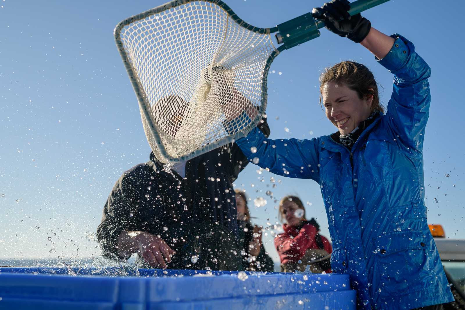 Woman holding a fishing net over splashing water