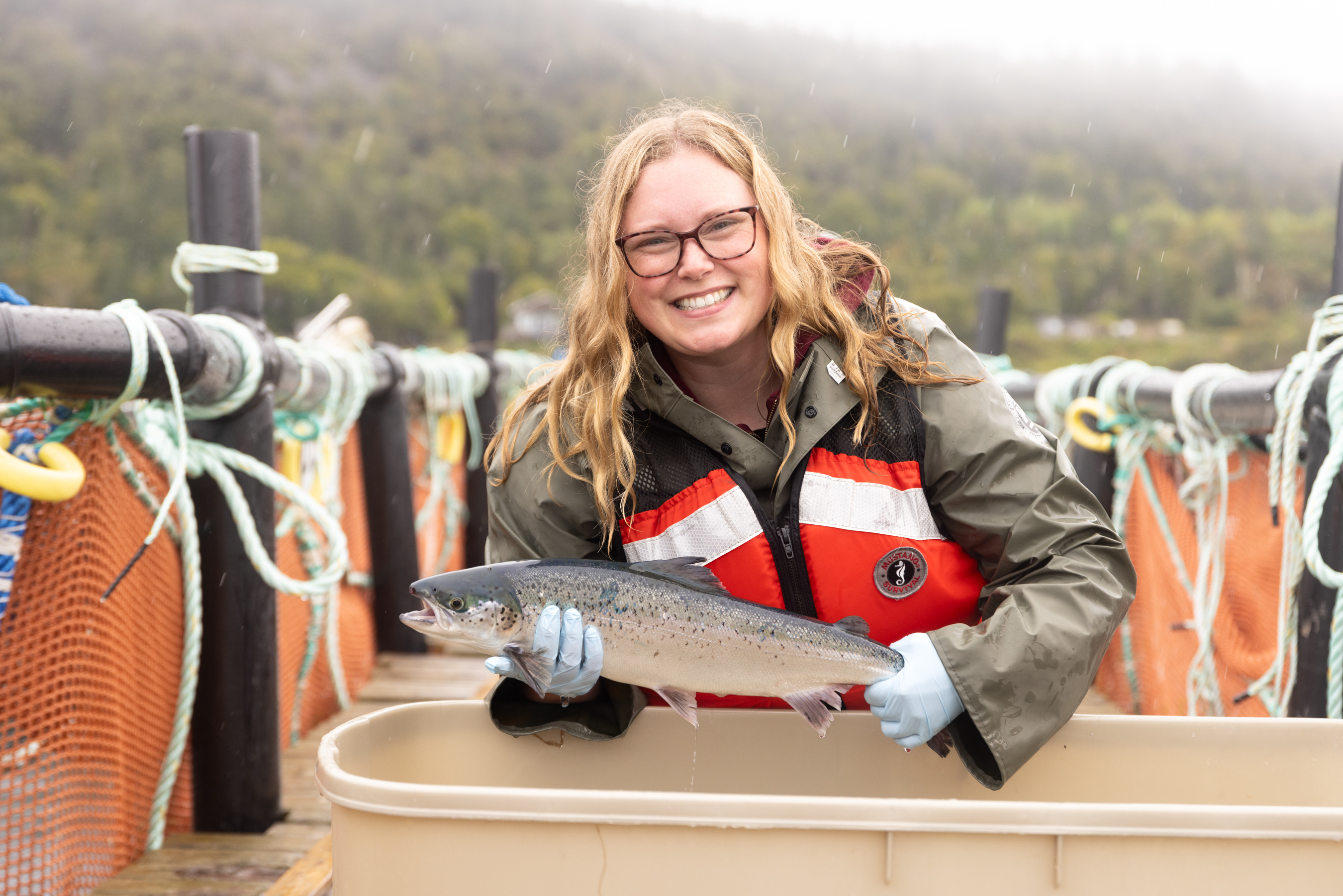 Woman in life vest holding a salmon